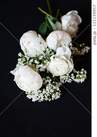 Fresh white peonies on a black, dark background. A condolence card. Wedding date. An invitation to a holiday. Congratulation.An empty space for text. View from above. He was lying flat. 111139957