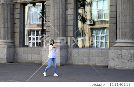 a confident young woman walks through the streets of the city, a woman smiles and enjoys life a confident young woman walks through the streets of the city, a woman smiles and enjoys life 111140118