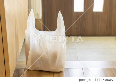 玄関に置かれた食品の入ったレジ袋のイメージ 111140685