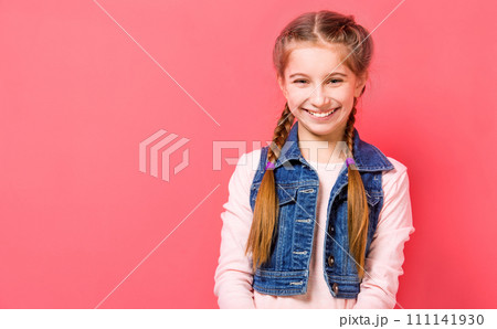 Smiling teen girl with two french braid in casual clothes posing over pink background 111141930