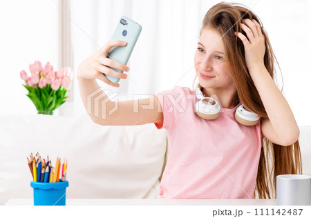 Beatiful teen making selfie of herself in cool headphones on breaks Beatiful teen making selfie of herself in cool headphones on breaks 111142487