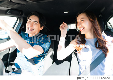 夏日に半袖でドライブを楽しむ若い夫婦 111142828