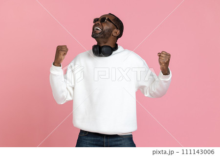 Overjoyed happy black man wearing white sweatshirt clenched fists Overjoyed happy black man wearing white sweatshirt clenched fists 111143006