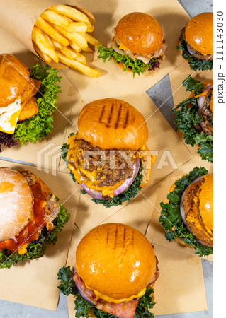 Big hamburgers and french fries on wooden table. Top view 111143030