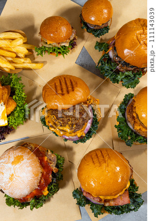 Close-up of hamburgers and french fries on wooden table 111143039