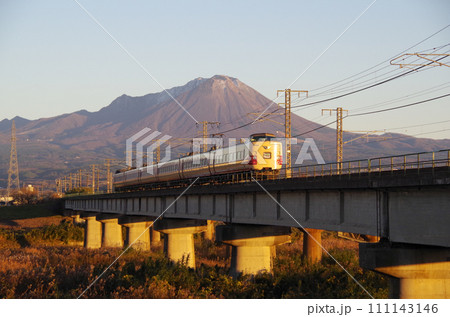 山肌が夕日で薄っすら赤色に染まった大山を背景に日野川の長い鉄橋を駆け抜ける復刻版国鉄色の特急やくも号 山肌が夕日で薄っすら赤色に染まった大山を背景に日野川の長い鉄橋を駆け抜ける復刻版国鉄色の特急やくも号 111143146