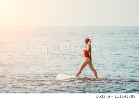 Woman sea yoga. Happy woman meditating in yoga pose on the beach, ocean and rock mountains. Motivation and inspirational fit and exercising. Healthy lifestyle outdoors in nature, fitness concept. Woman sea yoga. Happy woman meditating in yoga pose on the beach, ocean and rock mountains. Motivation and inspirational fit and exercising. Healthy lifestyle outdoors in nature, fitness concept. 111143399