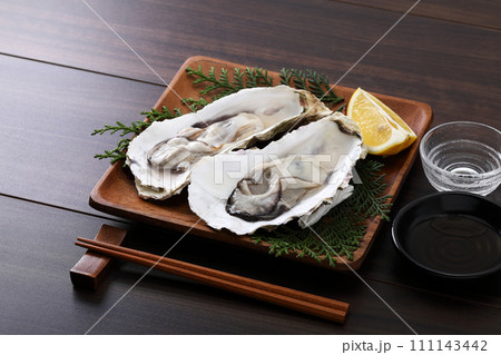 殻付きの生牡蠣と日本酒 111143442