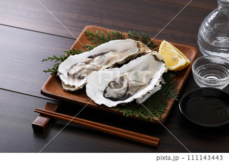 殻付きの生牡蠣と日本酒 111143443