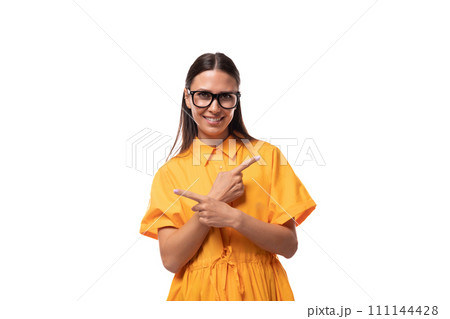 young pretty brunette lady dressed in a yellow dress shows her hands to the sides young pretty brunette lady dressed in a yellow dress shows her hands to the sides 111144428