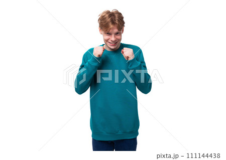 portrait of a cute caucasian young red-haired guy dressed in a blue pullover portrait of a cute caucasian young red-haired guy dressed in a blue pullover 111144438