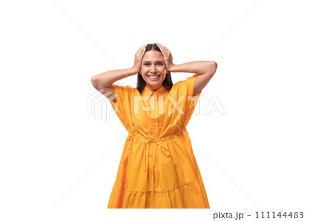 pretty young brunette lady dressed in a bright yellow dress on vacation 111144483