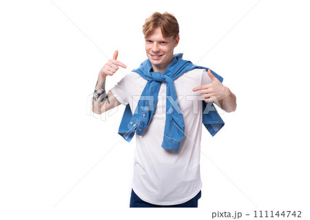 young authentic caucasian man with golden red hair with a tattoo on his arms is wearing a blue shirt 111144742