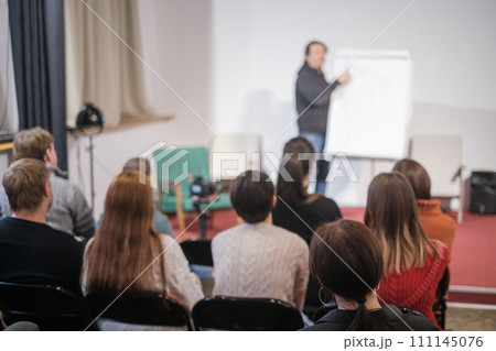 Engaged audience attentively listening to a speaker at a professional workshop event 111145076