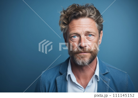 Portrait of a handsome mature man with a beard and mustache in a blue shirt on a blue background. 111145152