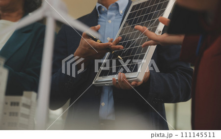 Close-up at tablet, Engineers pointing at tablet with their hands. To jointly design the use of renewable energy with wind and solar energy. Concept of using renewable energy. 111145511