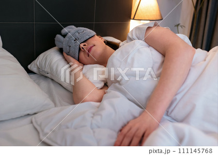 Caucasian woman wearing mask is fast asleep in her bed. Concept of insomnia and well sleeping with medicines Caucasian woman wearing mask is fast asleep in her bed. Concept of insomnia and well sleeping with medicines 111145768