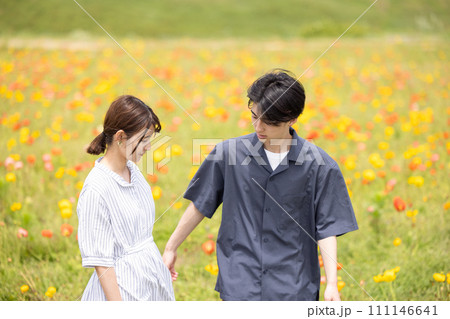 花畑の中を歩くカップル 111146641