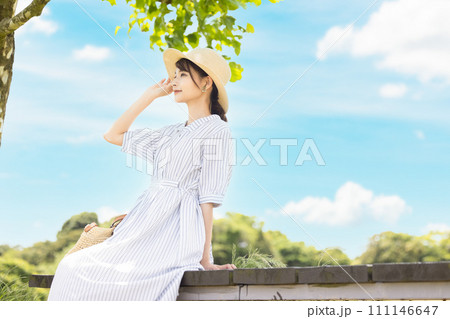 青空の下で寛ぐ女性 111146647