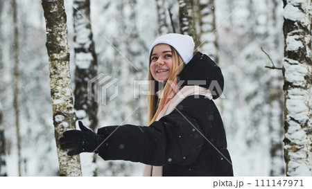 A girl walking in the forest in winter among the birches. A girl walking in the forest in winter among the birches. 111147971
