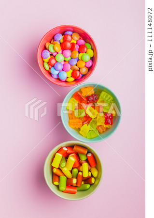 Colorful sweet jelly candies in bowl on pink background. Top view. Colorful sweet jelly candies in bowl on pink background. Top view. 111148072