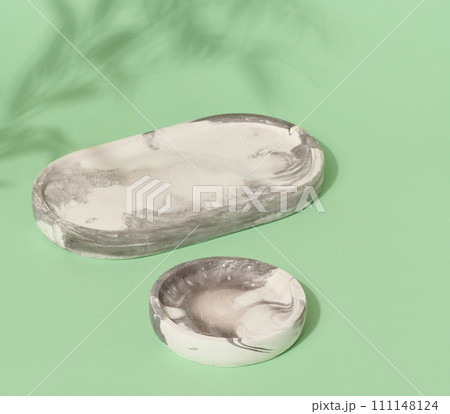 Empty round white marble stand on a green background, a place to display cosmetics and products 111148124