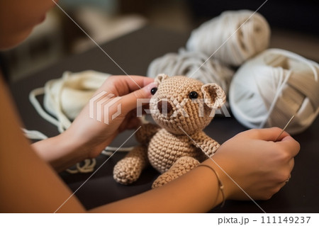 Close up view of hands crocheting a toy teddy bear. AI Generative 111149237