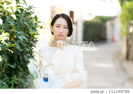 買い物から帰る主婦の困った表情 111149706