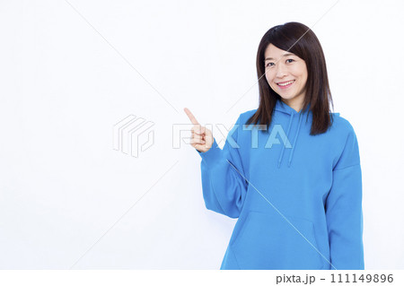 指差しをしているパーカーを着た40代の女性 111149896