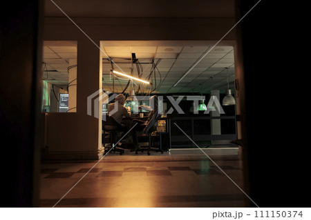 Diverse team of thieves coding trojan virus late at night, hacking computer system with malware. Young hackers planning to crack server, looking to steal passwords, malicious software. 111150374