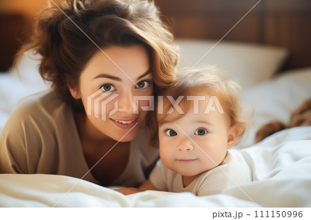 Young mother playfully engaging with her baby. Sweet bedroom moments concept. Generative AI. 111150996