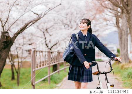 春に桜並木を自転車で学校に通う中学生・高校生・女子高生・女子高校生（通学・下校） 111152442