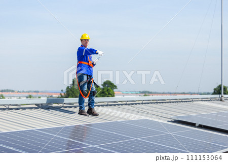 Technicians are installing and inspecting standards of solar panels on roof of an industrial 111153064