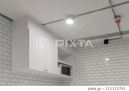 White Wall-Mounted Kitchen Cabinet with a Clean White Microwave Placed Inside White Wall-Mounted Kitchen Cabinet with a Clean White Microwave Placed Inside 111153701