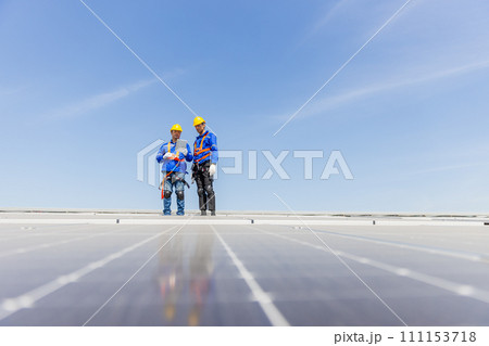 Technicians are installing and inspecting standards of solar panels on roof of an industrial. 111153718