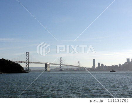 Tugboat heads towards Bay Bridge with San Francisco Downtown cityscape in the background 111153793