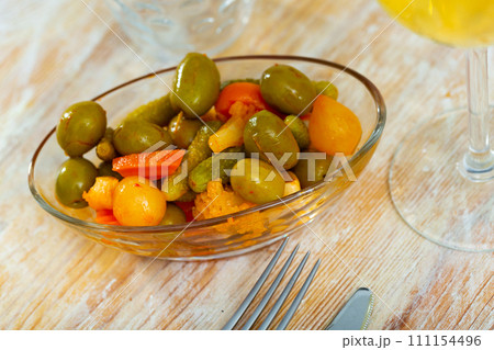 Tasty small serving of olives with carrots pickles and onions 111154496