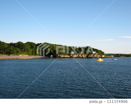 Beach, house on island shore and boats in the waters of Portland Harbor 111154906