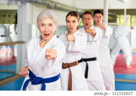 People of different ages performing kata in gym 111155027