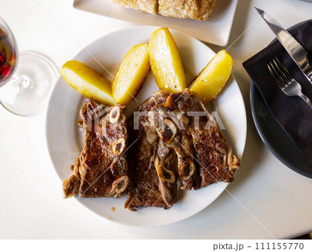 Tasty veal kebab and baked potatoes served at plate 111155770
