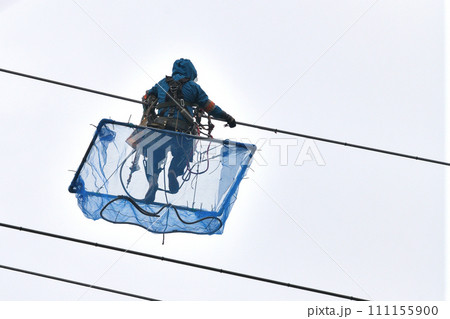 送電線の保全工事　小雨決行　送電鳶の作業風景 111155900