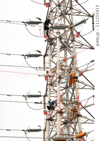 送電鉄塔の保全工事　小雨決行　送電線電工の作業風景 111155915
