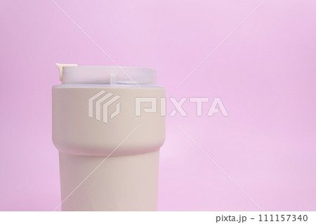 Closeup Travel Coffee Beige Mug, Thermo Hot Coffee Tumbler, Cropped Reusable Tea Mug with Seal Lid, Buckle, Vacuum Stainless Steel Cup on Pink Background, Mockup. Copy Space. Cold or Hot Beverages Closeup Travel Coffee Beige Mug, Thermo Hot Coffee Tumbler, Cropped Reusable Tea Mug with Seal Lid, Buckle, Vacuum Stainless Steel Cup on Pink Background, Mockup. Copy Space. Cold or Hot Beverages 111157340