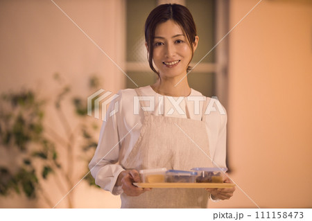 髪を結んでお夕食の準備をするビジネスウーマン ナイトルーティーン 髪を結んでお夕食の準備をするビジネスウーマン ナイトルーティーン 111158473