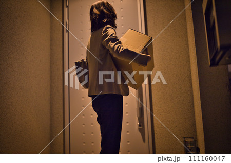 ビジネスウーマン のナイトルーティーン　置き配を持つ後ろ姿 111160047