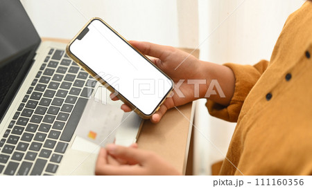 Woman holding plastic card making online payment purchase or transferring money in ebank app 111160356