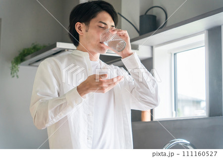 キッチンで内服薬・サプリ・医薬品を飲む病気の男性・投薬 111160527