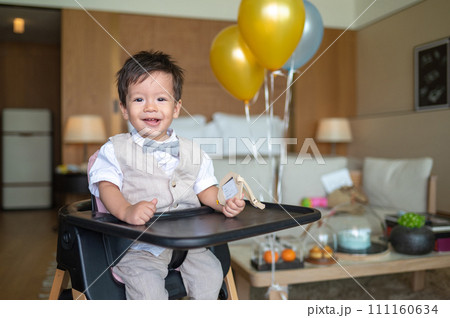 Baby boy's first birthday with cake in balloons 111160634