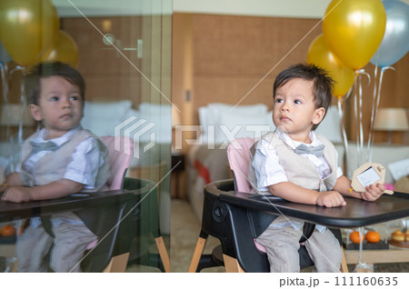 Baby boy's first birthday with cake in balloons 111160635