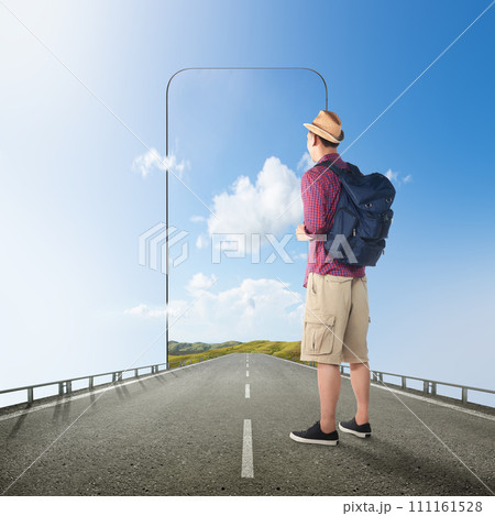 Asian man in a hat with a backpack standing on the street with a hill view on the mobile phone screen 111161528